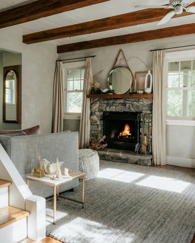 Warm cottage living room with stone fireplace, exposed beams, and natural light
