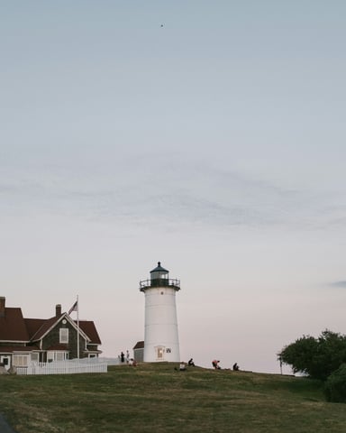 Cape Cod lighthouse with keeper's house at dusk on a grassy headland