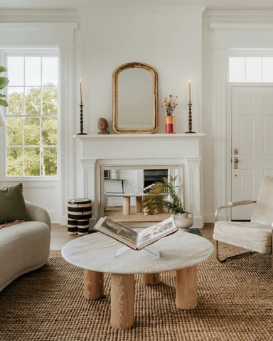 Bright airy living room with fireplace, natural light, and warm furnishings